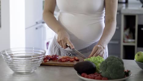 Captura-Recortada-De-Una-Mujer-Embarazada-Preparando-Ensalada-En-La-Cocina